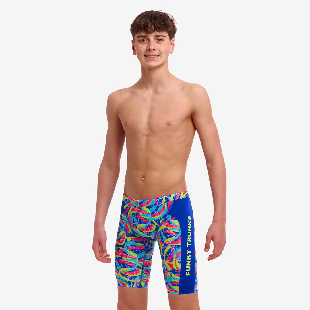 A boy wearing multicolored Funky Trunks Choppy Waters training jammers with the Funky Trunks brand logo on the leg.