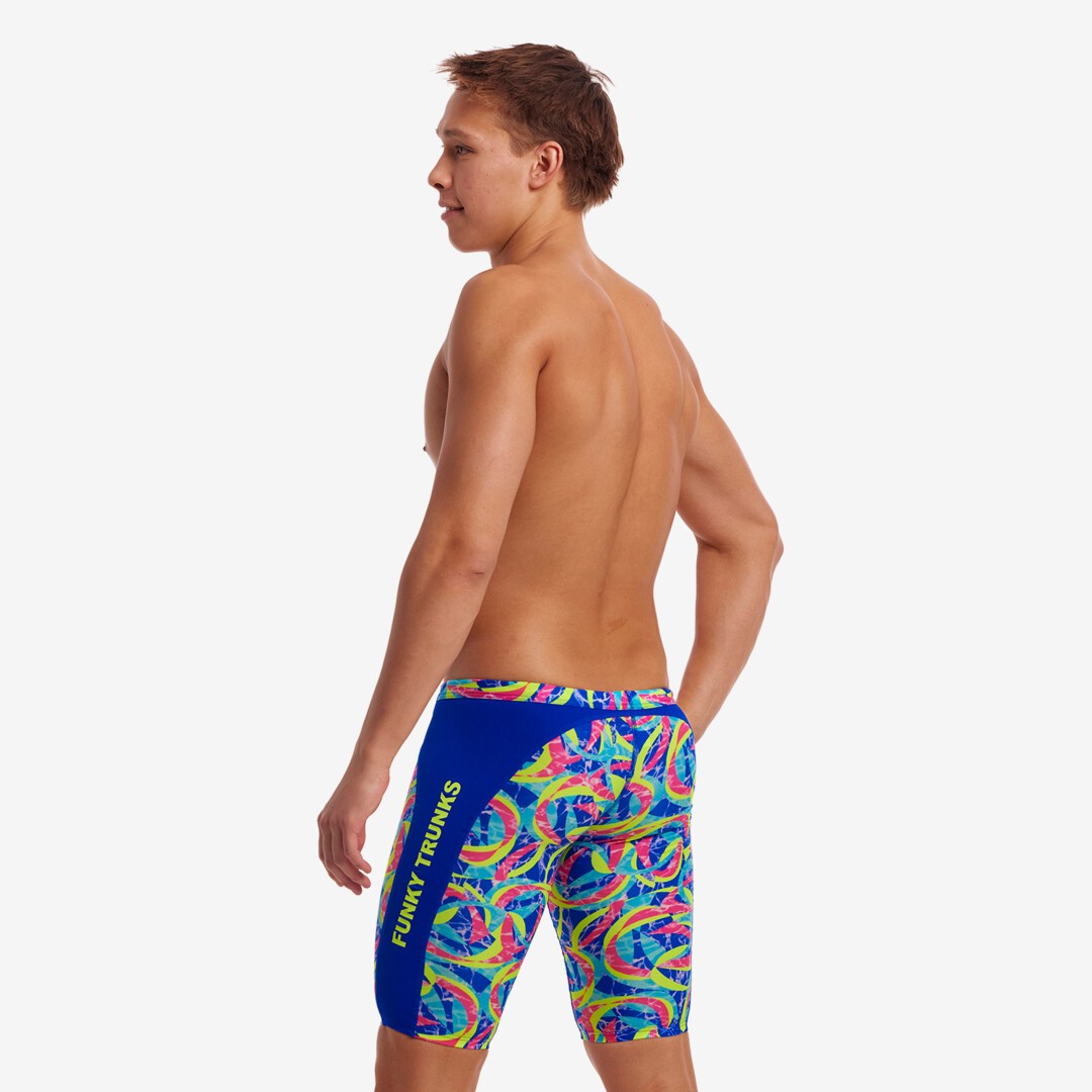 Side view of a man wearing multicolored Funky Trunks Choppy Water jammers with Funky Trunks brand logo on the legs.