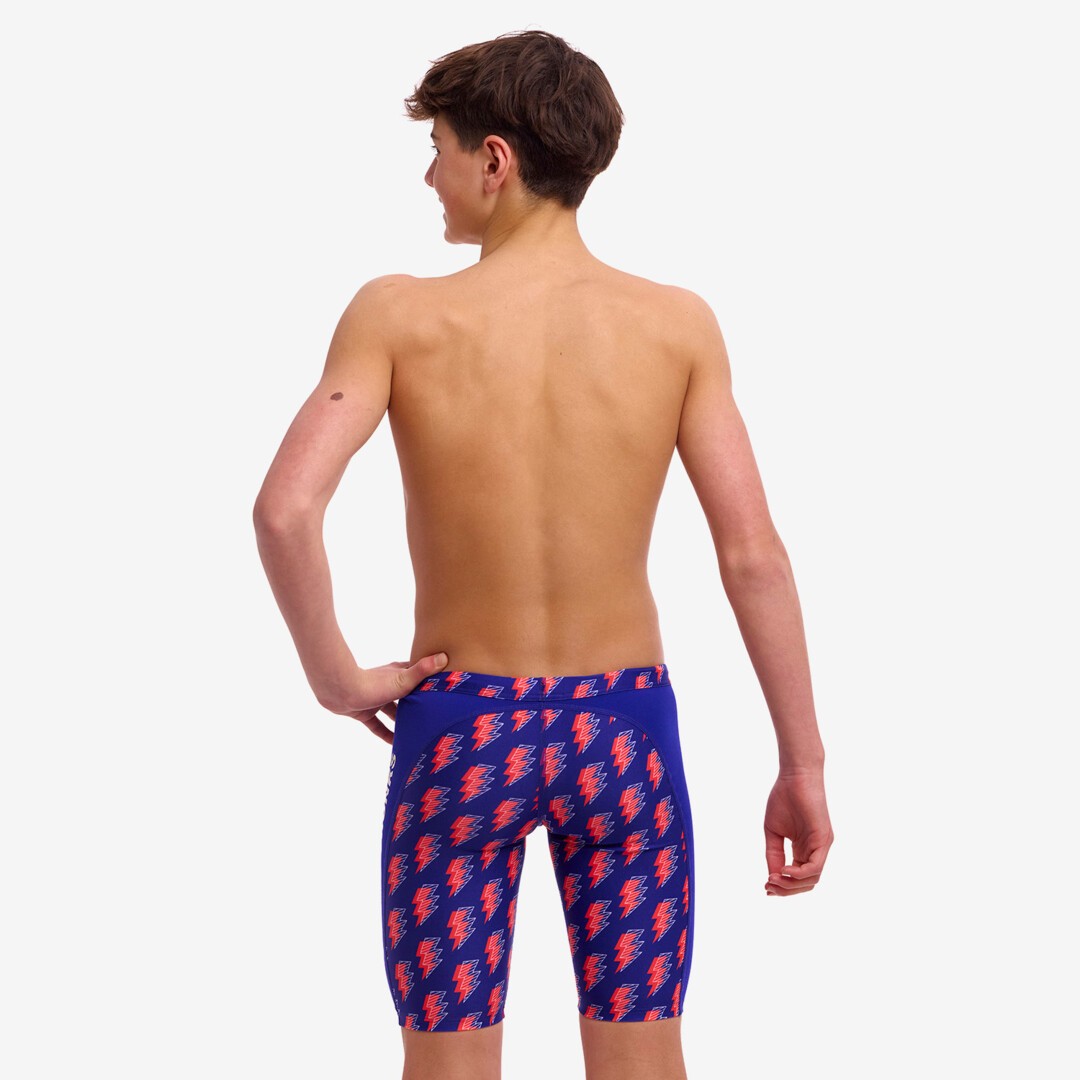 Back view of a boy wearing blue and red Funky Trunks Flash Boy's Training jammers with a wide elastic waistband and leg openings.