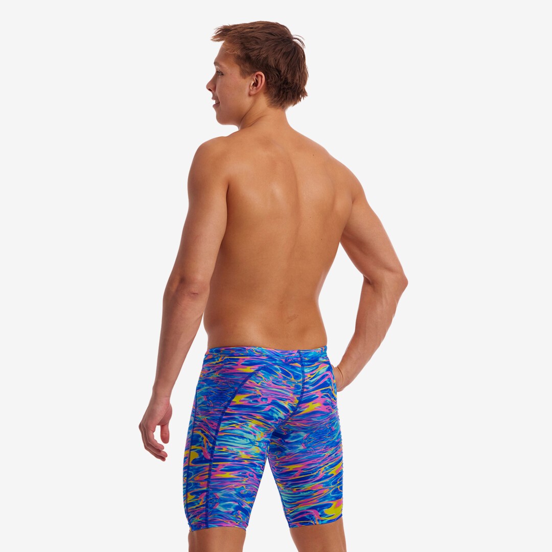 The side view of a man wearing multicolored Stir Crazy Funky Trunks jammers