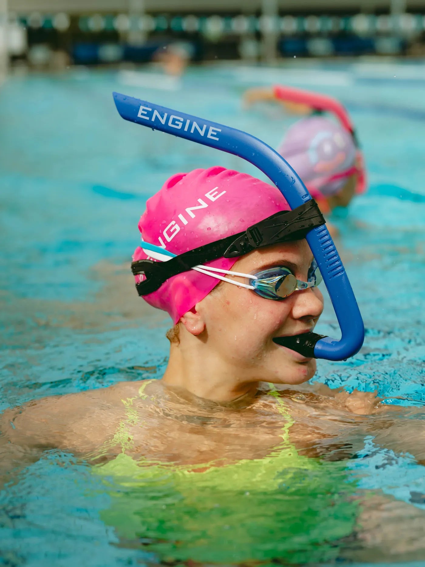 Swimmer in water wearing a blue 'Engine' front snorkel