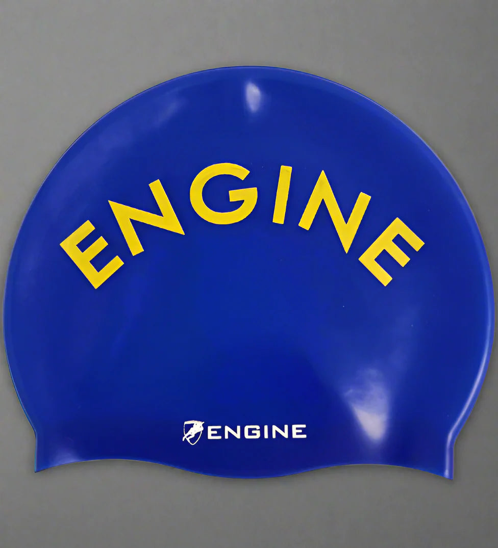 Royal blue swim cap with 'ENGINE' printed in yellow on a grey background