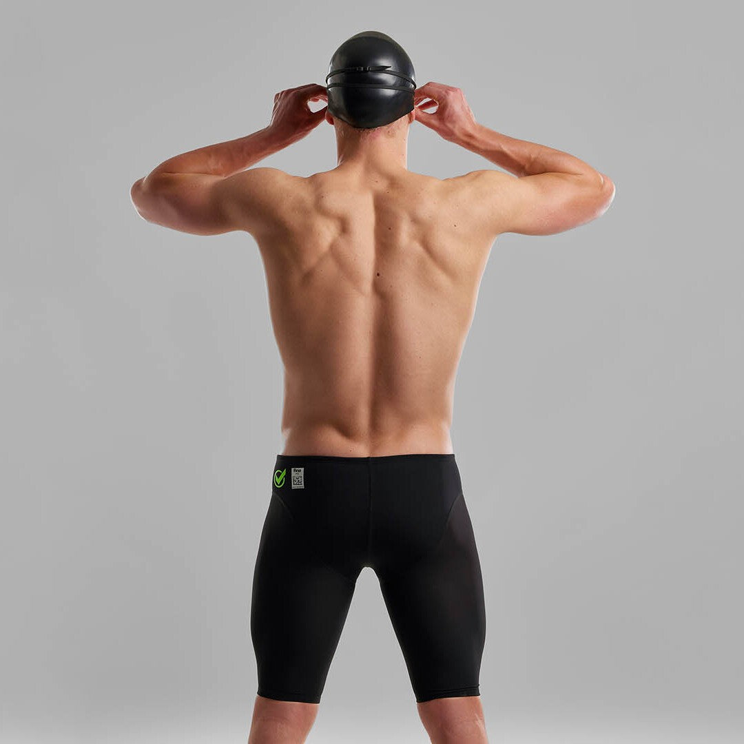 Back view of a man wearing Funky Trunks Black Attack Men's Apex Viper Jammers with a black Funky Trunks swim cap and goggles.