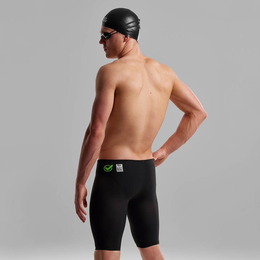 Side view of a man wearing Funky Trunks Black Attack Men's Apex Viper Jammers with a black Funky Trunks swim cap and goggles.