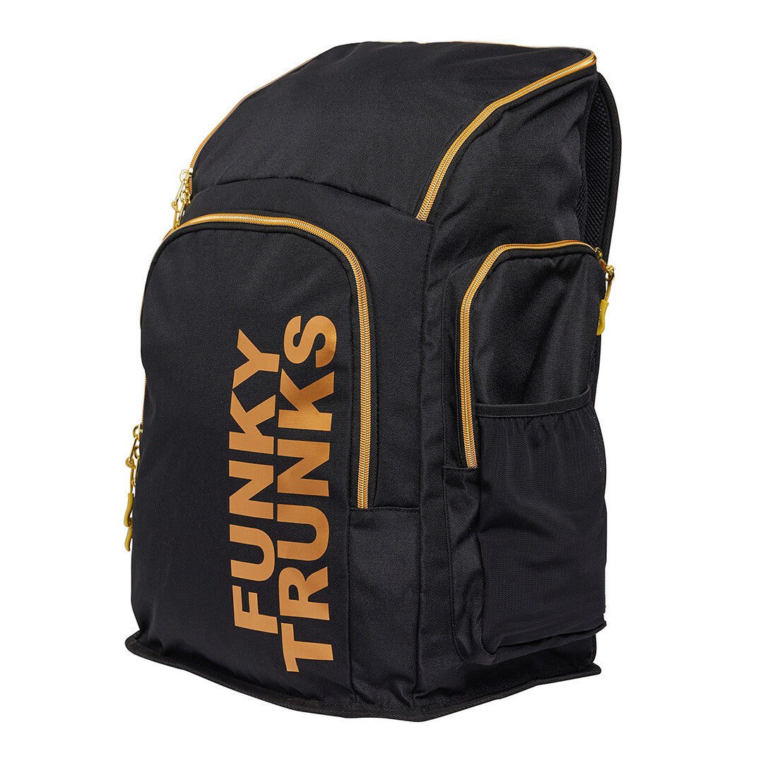 A black Funky Trunks backpack with gold trim and the brand name 'Funky Trunks' printed in gold on the front.