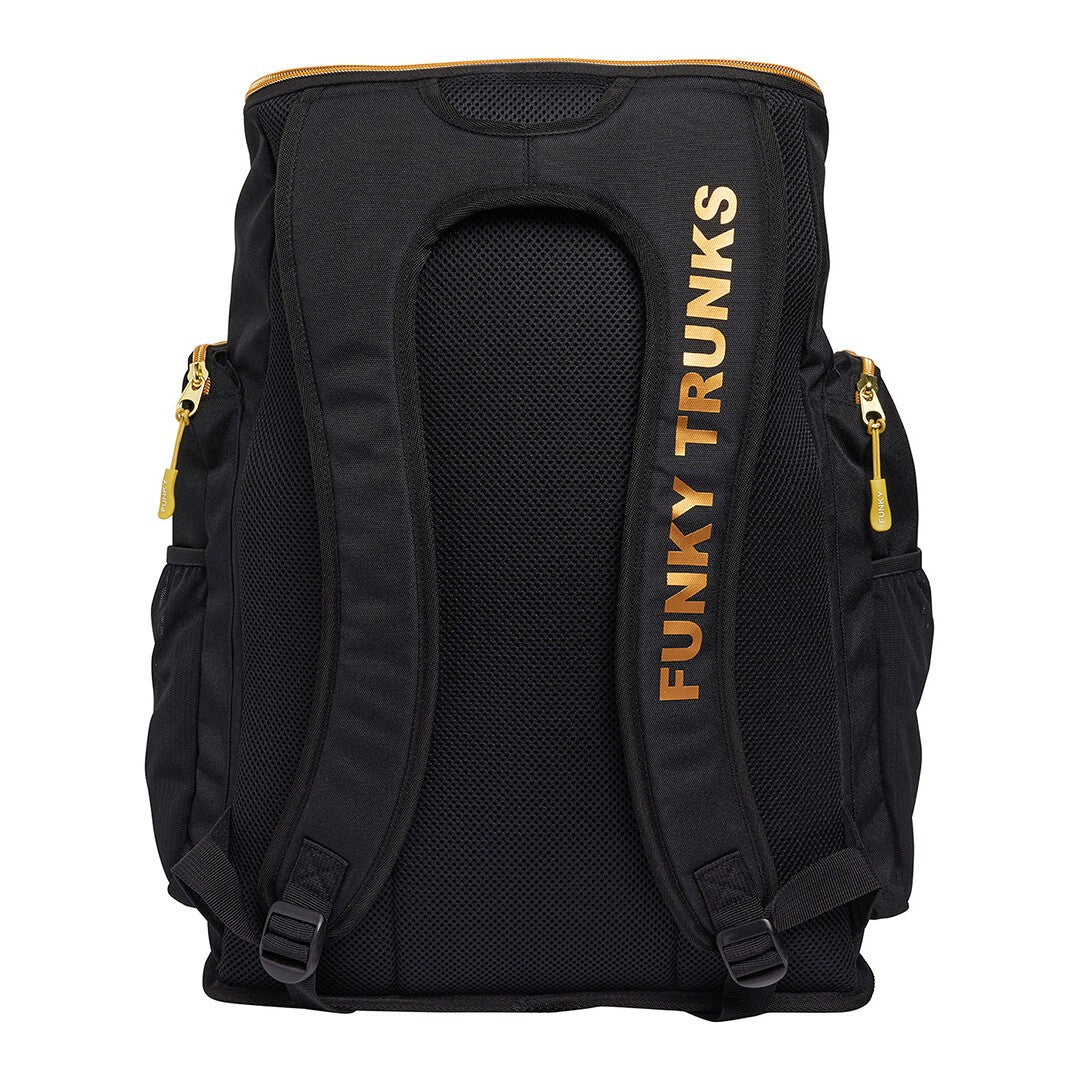 Back view of a black Funky Trunks backpack with gold trim and the brand name 'Funky Trunks' printed in gold on the right back strap.