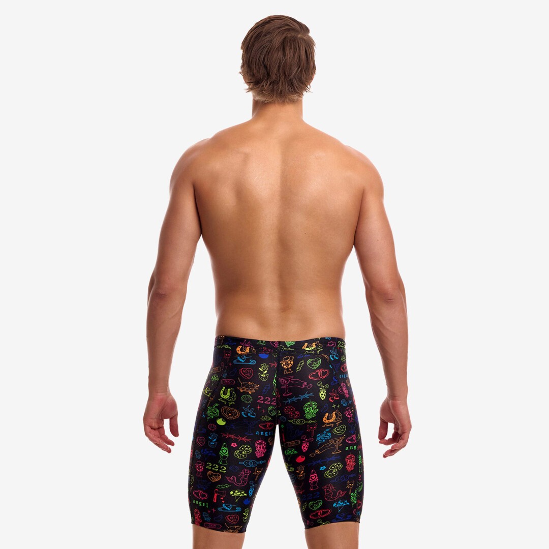 A shirtless male model with his back to the camera wearing multicoloured swimming jammers with a colourful "doodles" pattern from Funky Trunks 