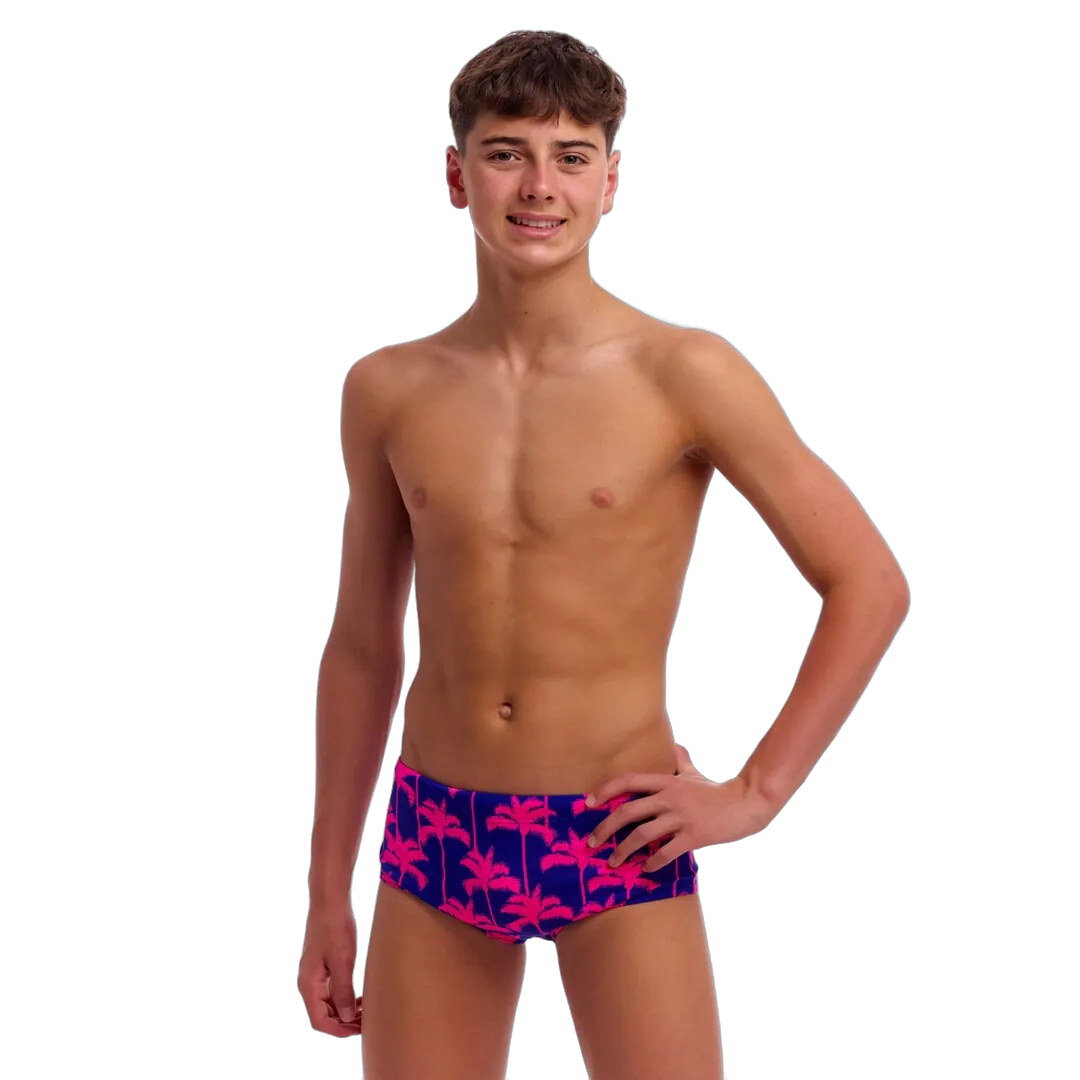 Young man wearing colourful swim trunks with palm tree pattern