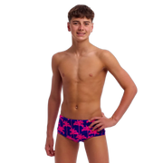 Young man wearing colourful swim trunks with palm tree pattern