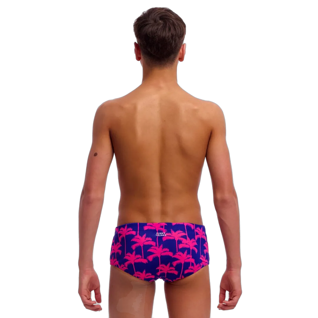 Young man wearing colourful swim trunks with palm tree pattern