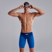 A man wearing Funky Trunks Pressure Point Men's Apex Viper Jammers with Funky Trunks logo, swim cap, and goggles.
