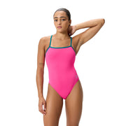 Woman wearing a pink 'SPEEDO' swimsuit with dark teal straps on a white background