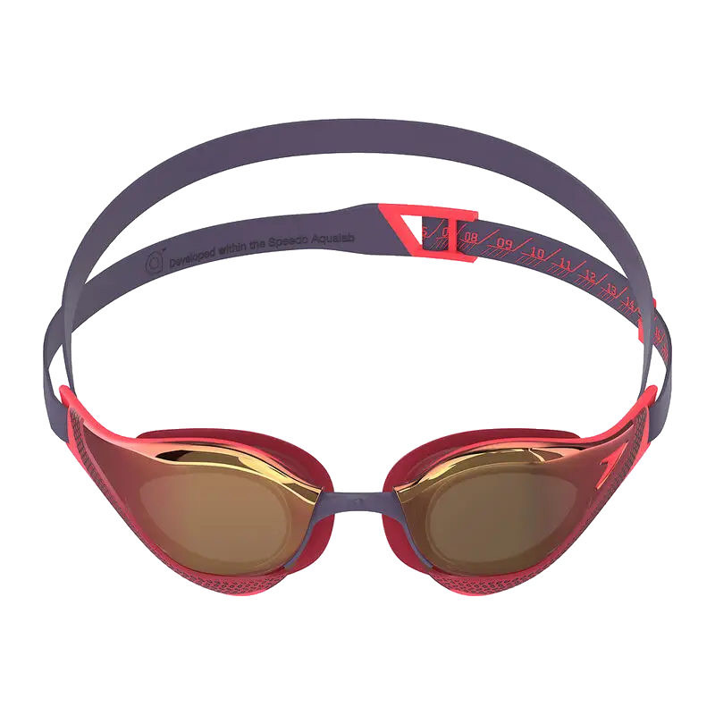 A pair of Speedo Fastskin pure focus swim goggles with a red and dark gray frame, gold mirrored lenses, and a dark gray adjustable strap with red branding.