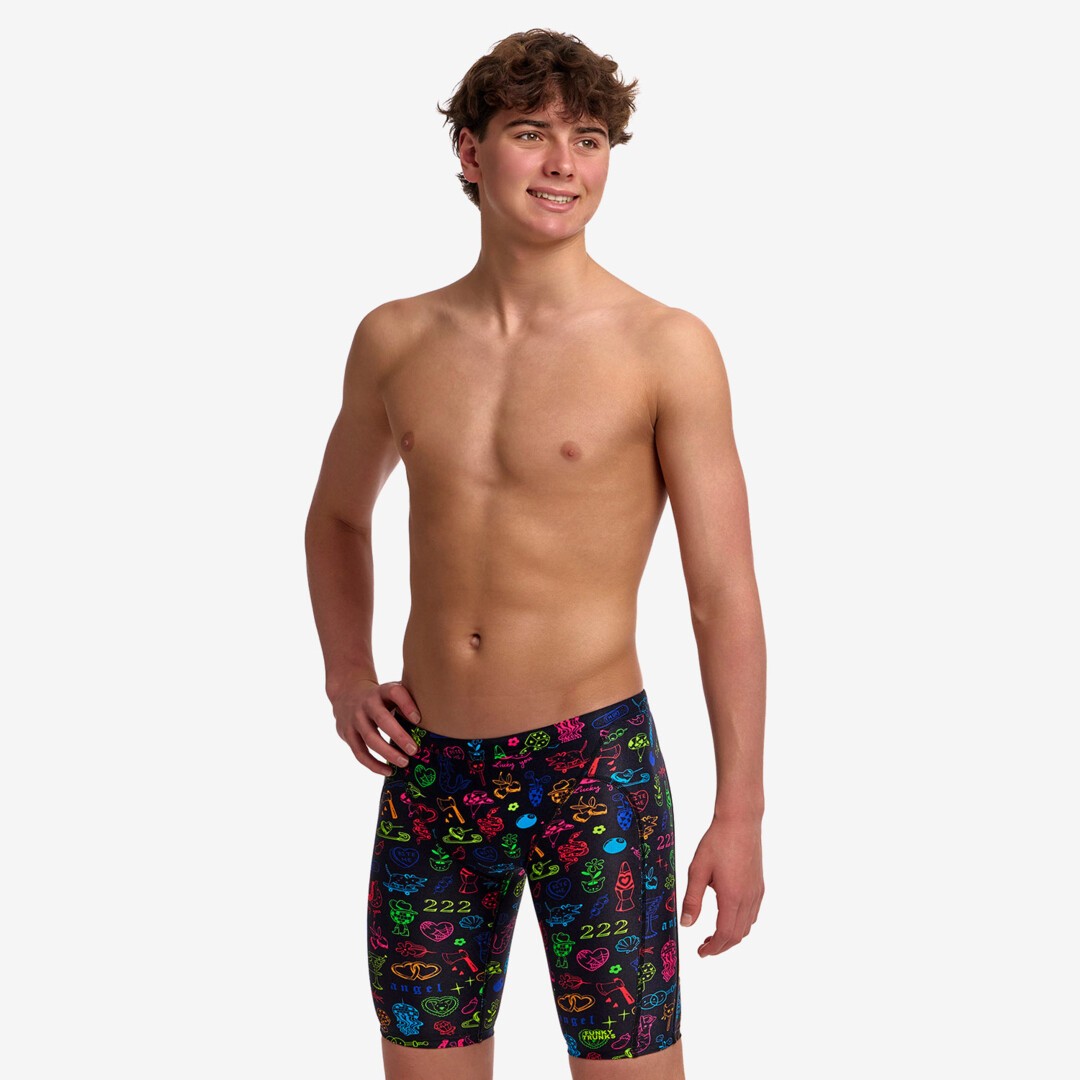 A young man modelling black swim jammers with a colourful "doodles" pattern from Funky Trunks.