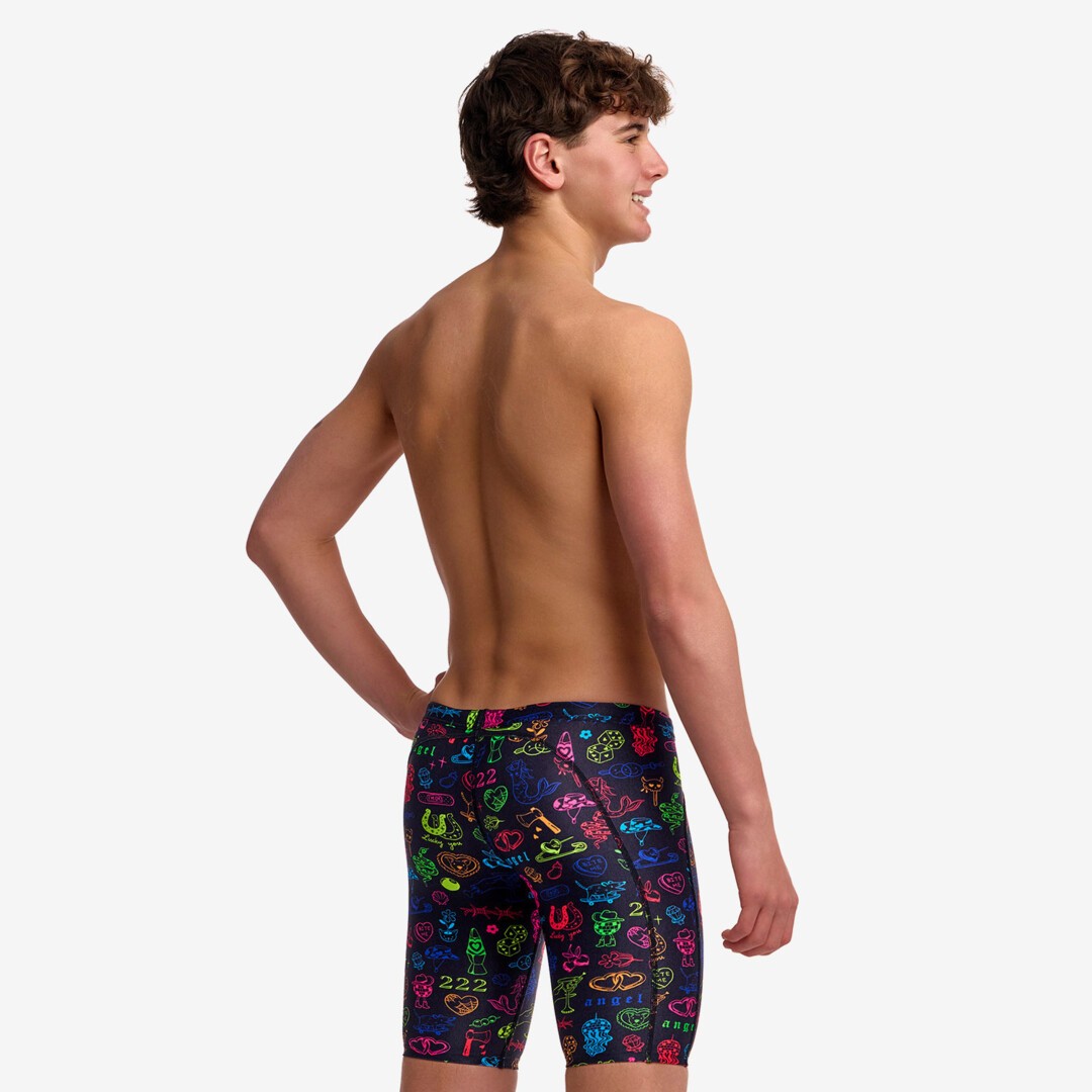 A young man form the back modelling black swim jammers with a colourful "doodles" pattern from Funky Trunks.