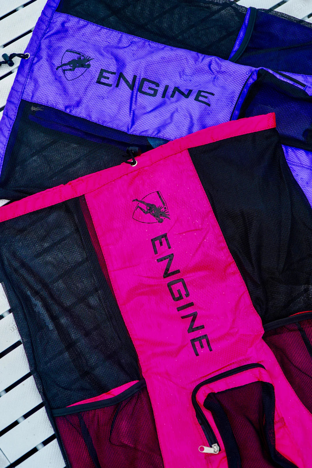 Two drawstring mesh bags with 'Engine' branding one pink and one purple