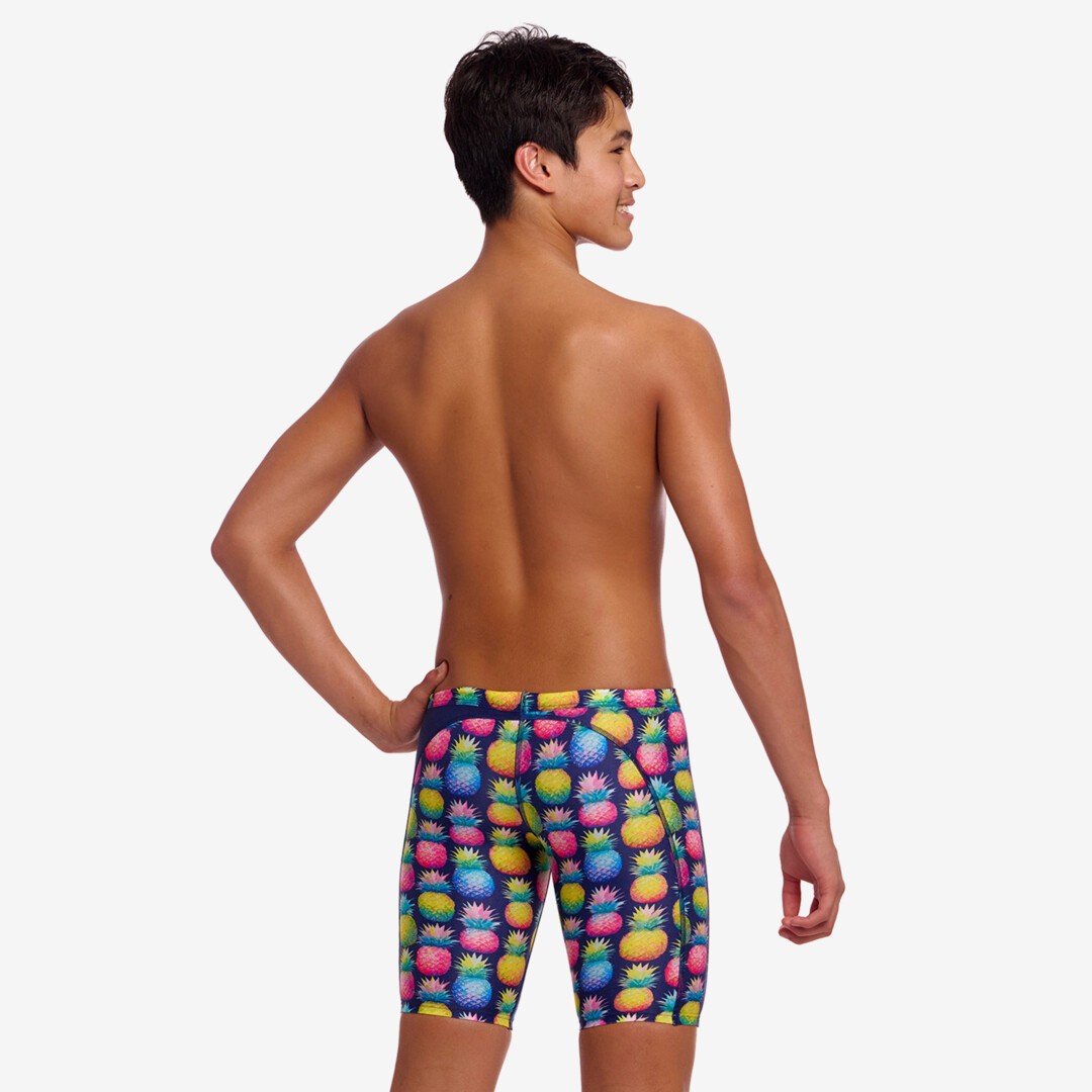 Person wearing colorful pineapple-patterned swim jammers on a white background