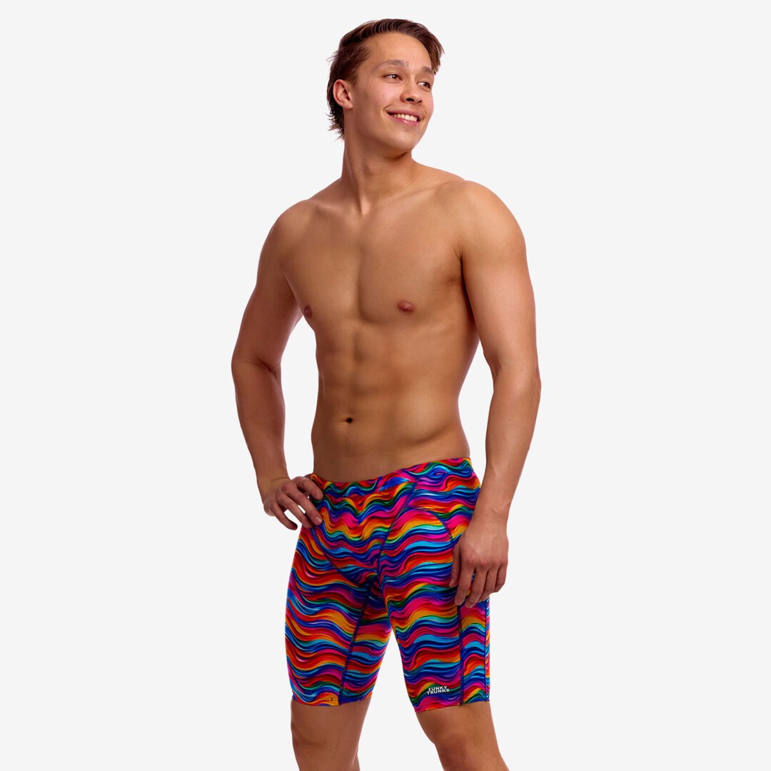 Man wearing colourful wave patterned swim jammers on a white background