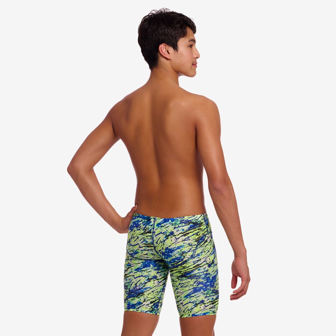Back view of a person wearing colourful swim jammers on a plain background