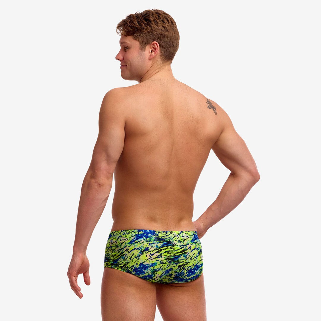 A shirtless man from behind wearing fluoro green and blue patterned swim trunks