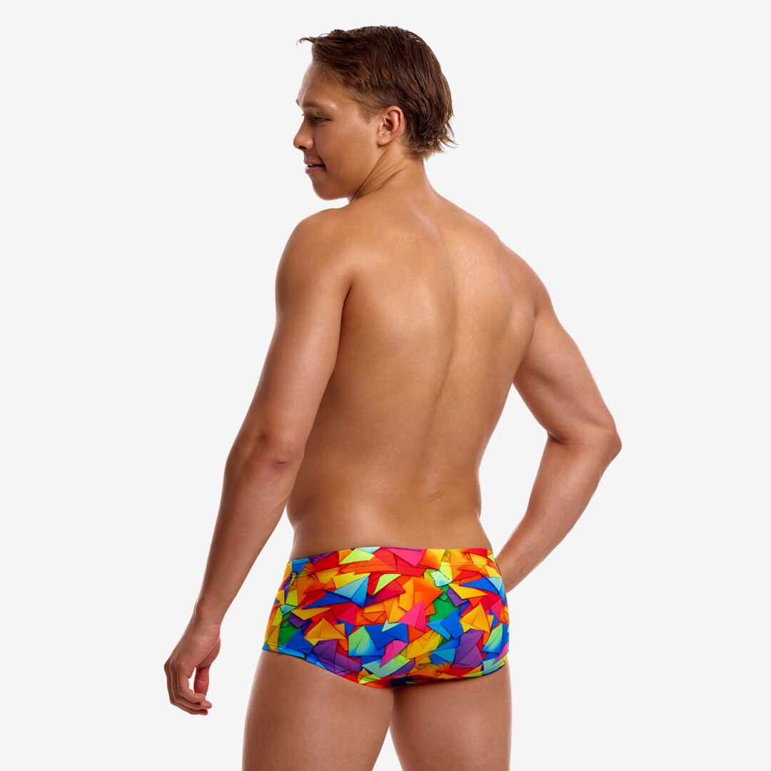 A shirtless man shown from the back wearing bright multicolored geometric print swim trunks