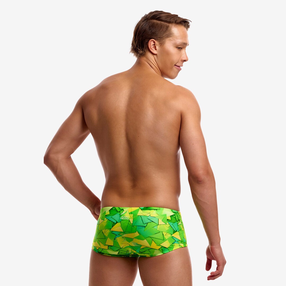 A shirtless man from behind wearing bright green and yellow geometric print swim trunks