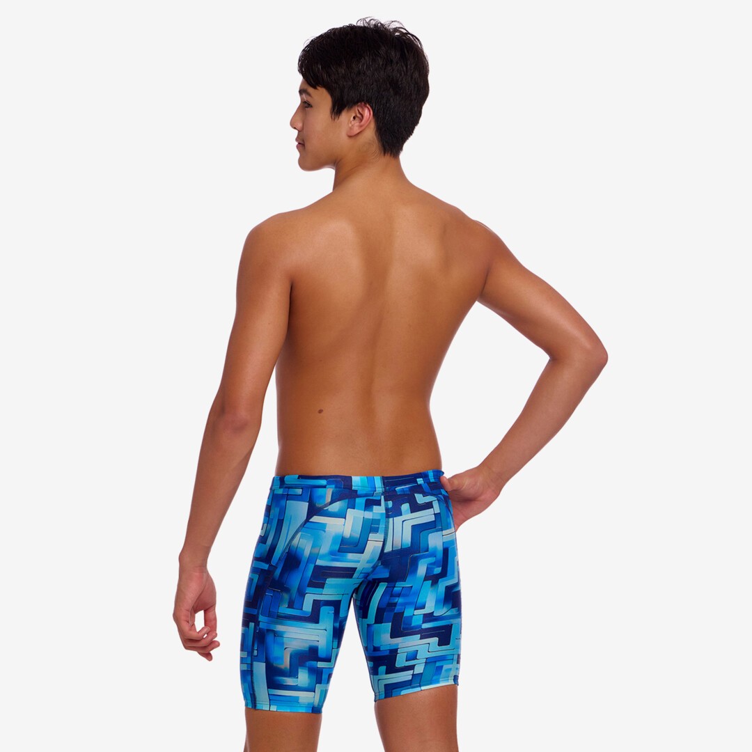 Back view of a person wearing blue geometric patterned swim jammers on a white background