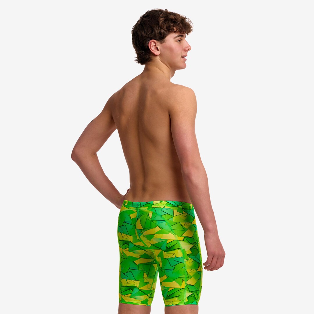 A young man shown from the back wearing Try Tonic Funky Trunks swimming jammers with a green and yellow abstract pattern