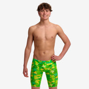 A young man modelling bright green and yellow geometric patterned swim jammers from Funky Trunks.